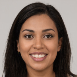 Joyful latino young-adult female with long  brown hair and brown eyes