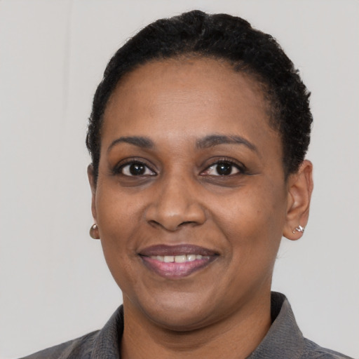 Joyful black adult female with short  black hair and brown eyes