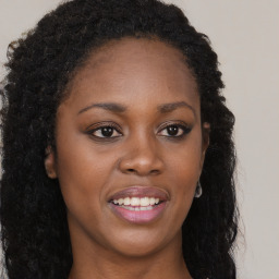 Joyful black young-adult female with long  brown hair and brown eyes