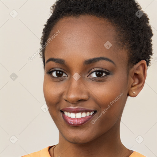 Joyful black young-adult female with short  brown hair and brown eyes