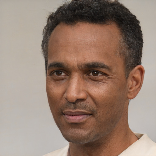 Joyful latino adult male with short  black hair and brown eyes