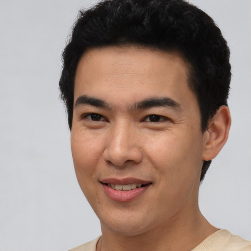 Joyful asian young-adult male with short  brown hair and brown eyes