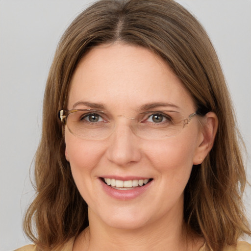 Joyful white adult female with long  brown hair and grey eyes