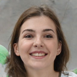 Joyful white young-adult female with medium  brown hair and green eyes