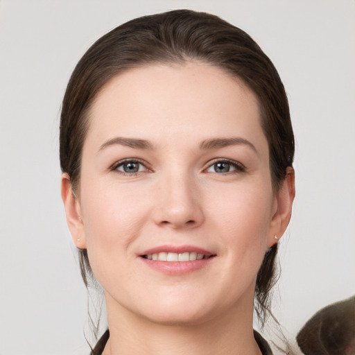 Joyful white young-adult female with short  brown hair and grey eyes