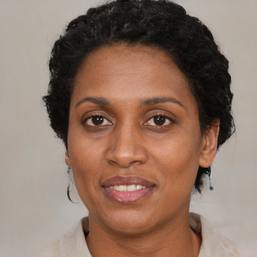 Joyful black adult female with short  black hair and brown eyes