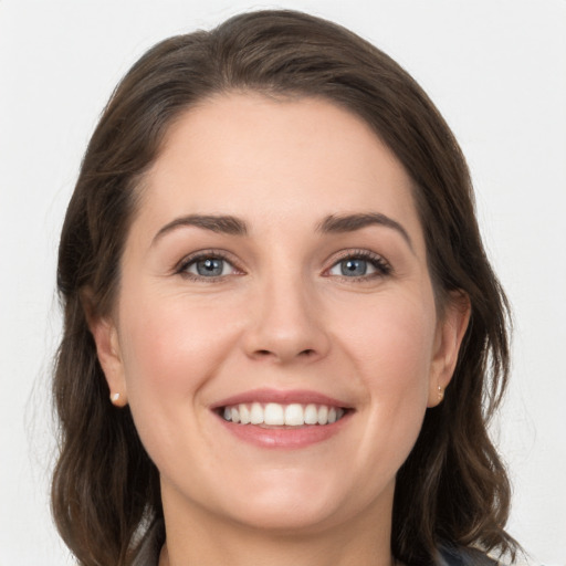 Joyful white young-adult female with medium  brown hair and grey eyes