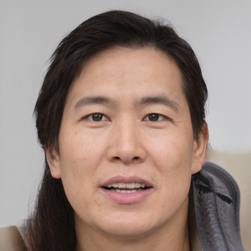 Joyful asian adult male with medium  brown hair and brown eyes