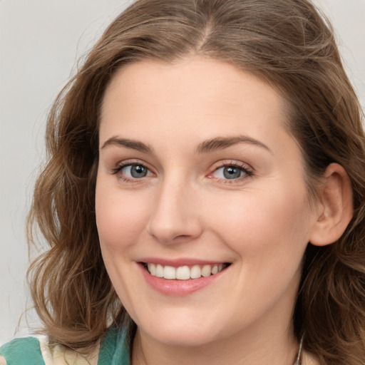 Joyful white young-adult female with long  brown hair and green eyes