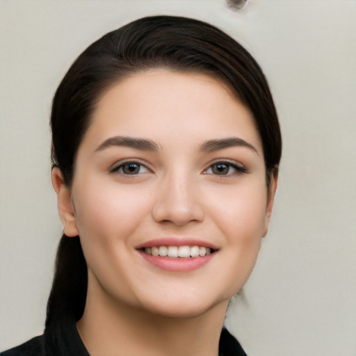 Joyful white young-adult female with long  black hair and brown eyes