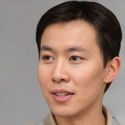 Joyful asian young-adult male with short  brown hair and brown eyes