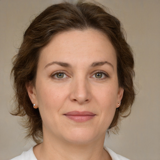 Joyful white adult female with medium  brown hair and green eyes