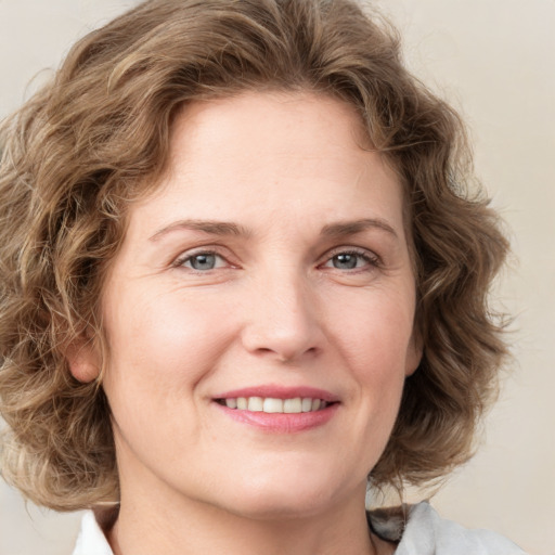 Joyful white adult female with medium  brown hair and green eyes