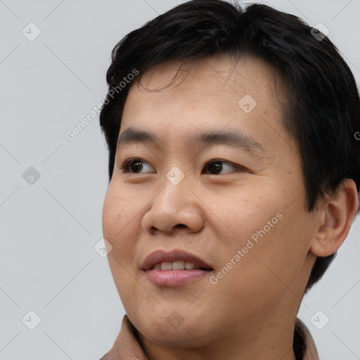 Joyful asian young-adult male with short  black hair and brown eyes