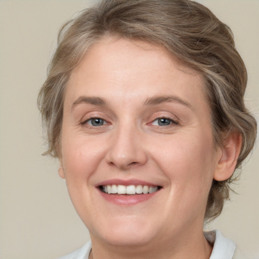 Joyful white adult female with medium  brown hair and grey eyes