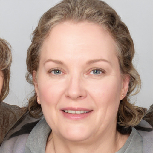 Joyful white adult female with medium  brown hair and blue eyes