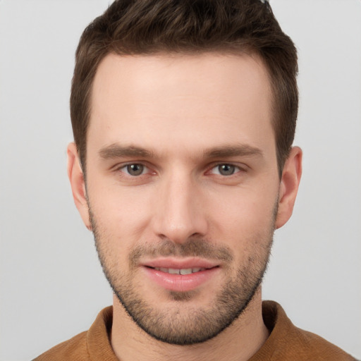 Joyful white young-adult male with short  brown hair and grey eyes