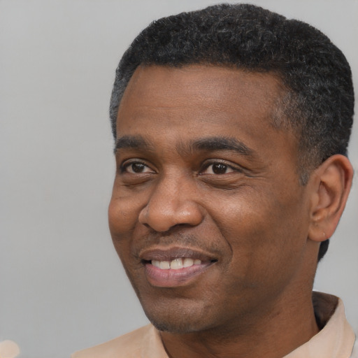 Joyful black adult male with short  black hair and brown eyes