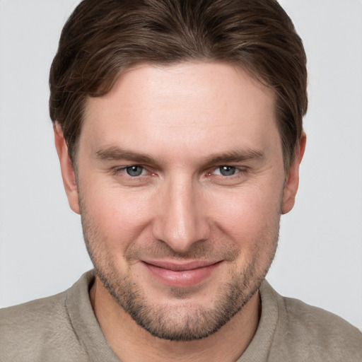 Joyful white young-adult male with short  brown hair and grey eyes