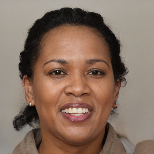 Joyful black adult female with medium  brown hair and brown eyes