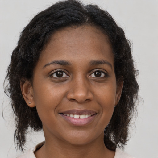Joyful black young-adult female with medium  brown hair and brown eyes