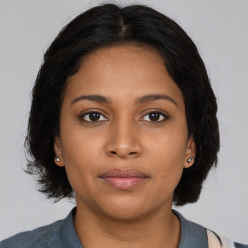 Joyful black young-adult female with medium  black hair and brown eyes