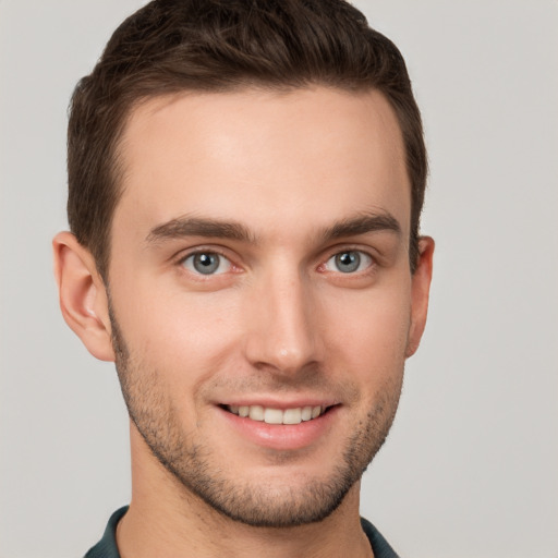 Joyful white young-adult male with short  brown hair and grey eyes