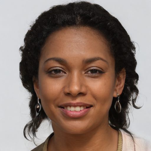 Joyful black young-adult female with long  black hair and brown eyes
