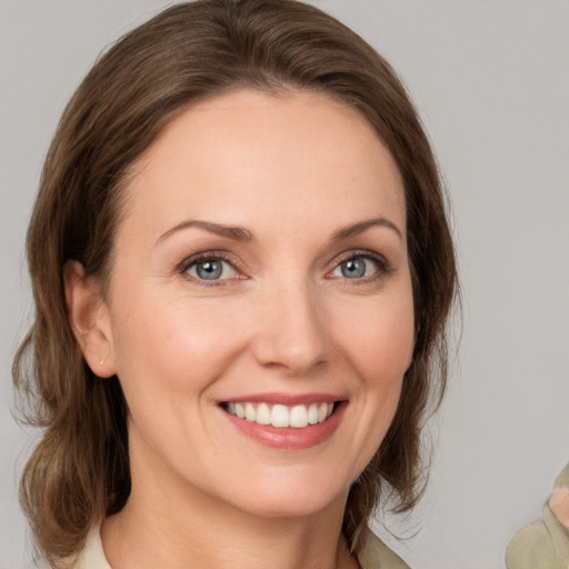 Joyful white young-adult female with medium  brown hair and green eyes