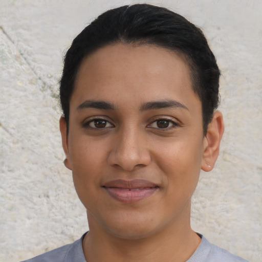 Joyful latino young-adult female with short  black hair and brown eyes