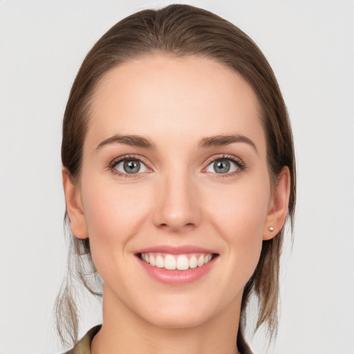 Joyful white young-adult female with medium  brown hair and grey eyes