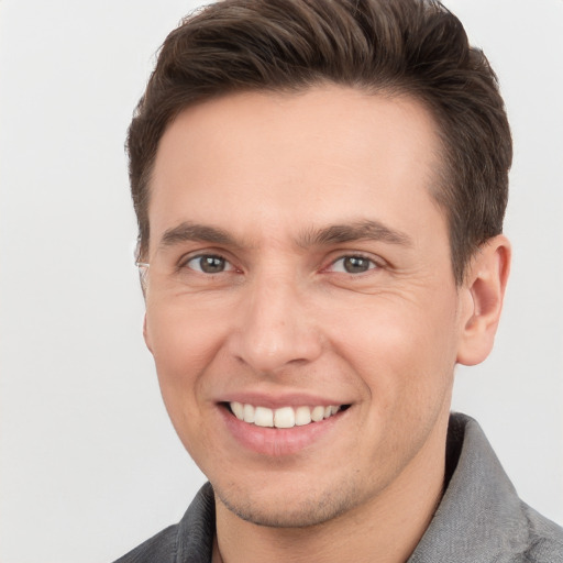 Joyful white young-adult male with short  brown hair and grey eyes