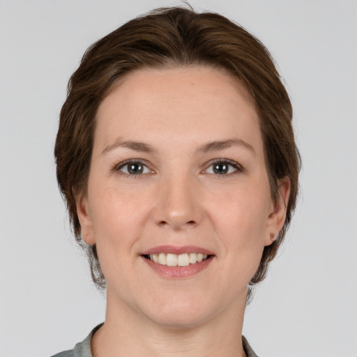 Joyful white adult female with medium  brown hair and grey eyes