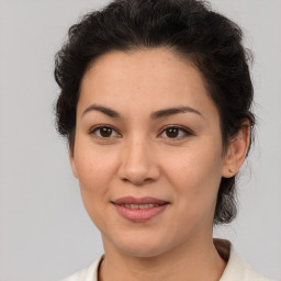 Joyful latino young-adult female with medium  brown hair and brown eyes