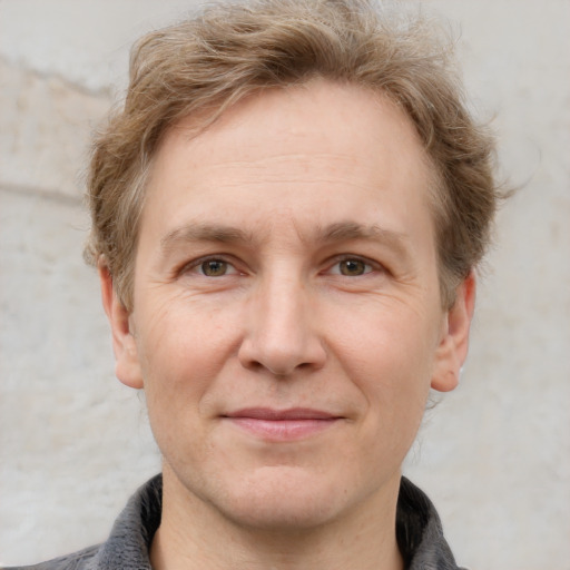 Joyful white adult male with short  brown hair and grey eyes