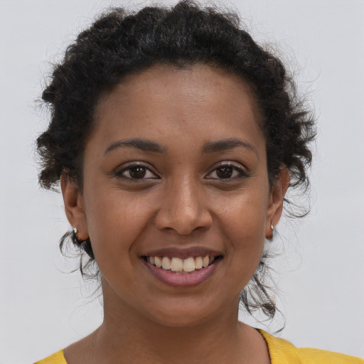 Joyful black young-adult female with short  brown hair and brown eyes