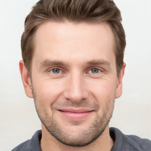 Joyful white young-adult male with short  brown hair and grey eyes