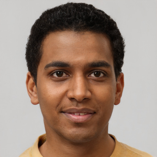 Joyful black young-adult male with short  brown hair and brown eyes