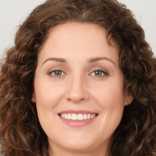 Joyful white young-adult female with long  brown hair and green eyes