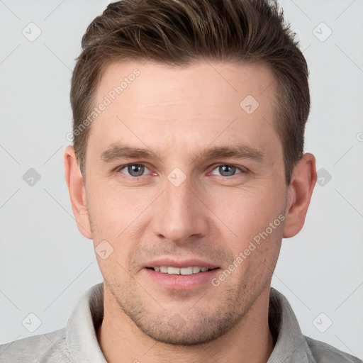 Joyful white young-adult male with short  brown hair and grey eyes