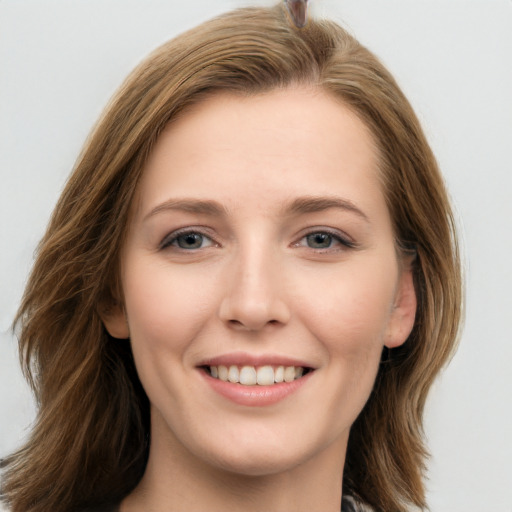 Joyful white young-adult female with long  brown hair and grey eyes