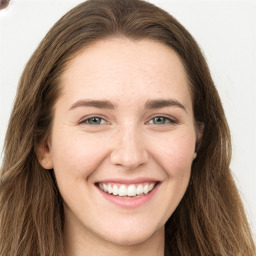 Joyful white young-adult female with long  brown hair and green eyes