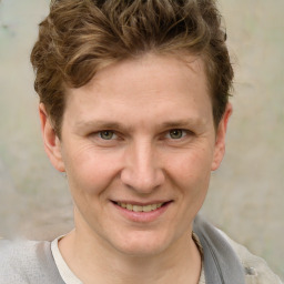 Joyful white adult male with short  brown hair and grey eyes