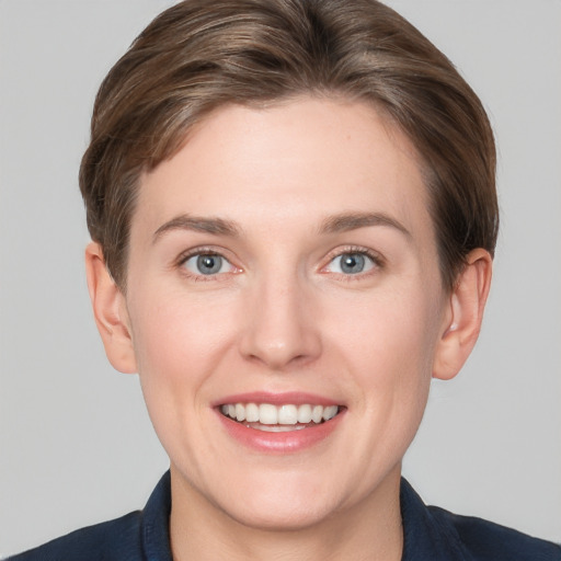 Joyful white young-adult female with short  brown hair and grey eyes