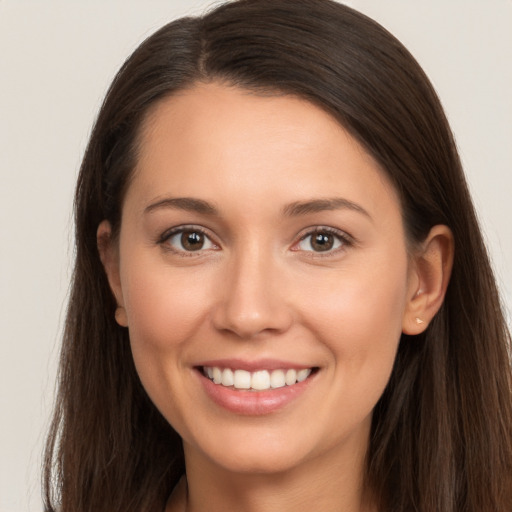 Joyful white young-adult female with long  brown hair and brown eyes