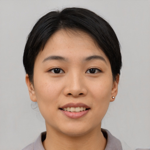 Joyful asian young-adult female with short  black hair and brown eyes