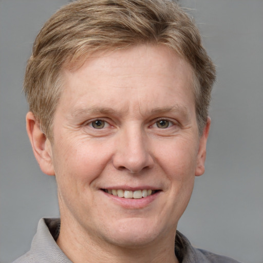 Joyful white adult male with short  brown hair and grey eyes