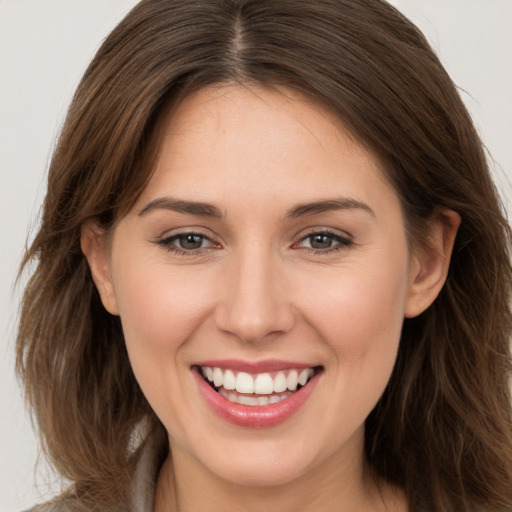 Joyful white young-adult female with long  brown hair and brown eyes