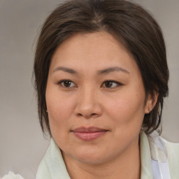 Joyful asian adult female with medium  brown hair and brown eyes