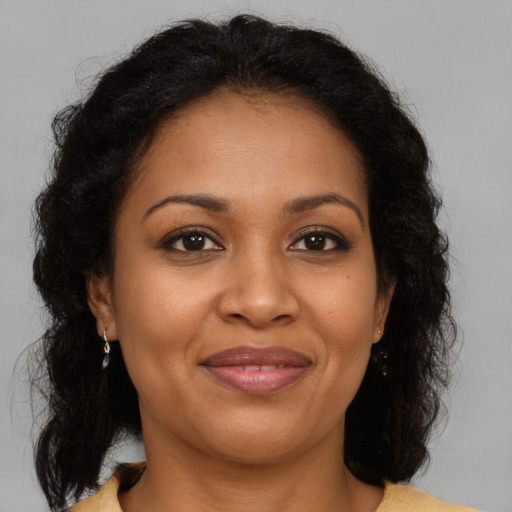 Joyful black adult female with medium  brown hair and brown eyes